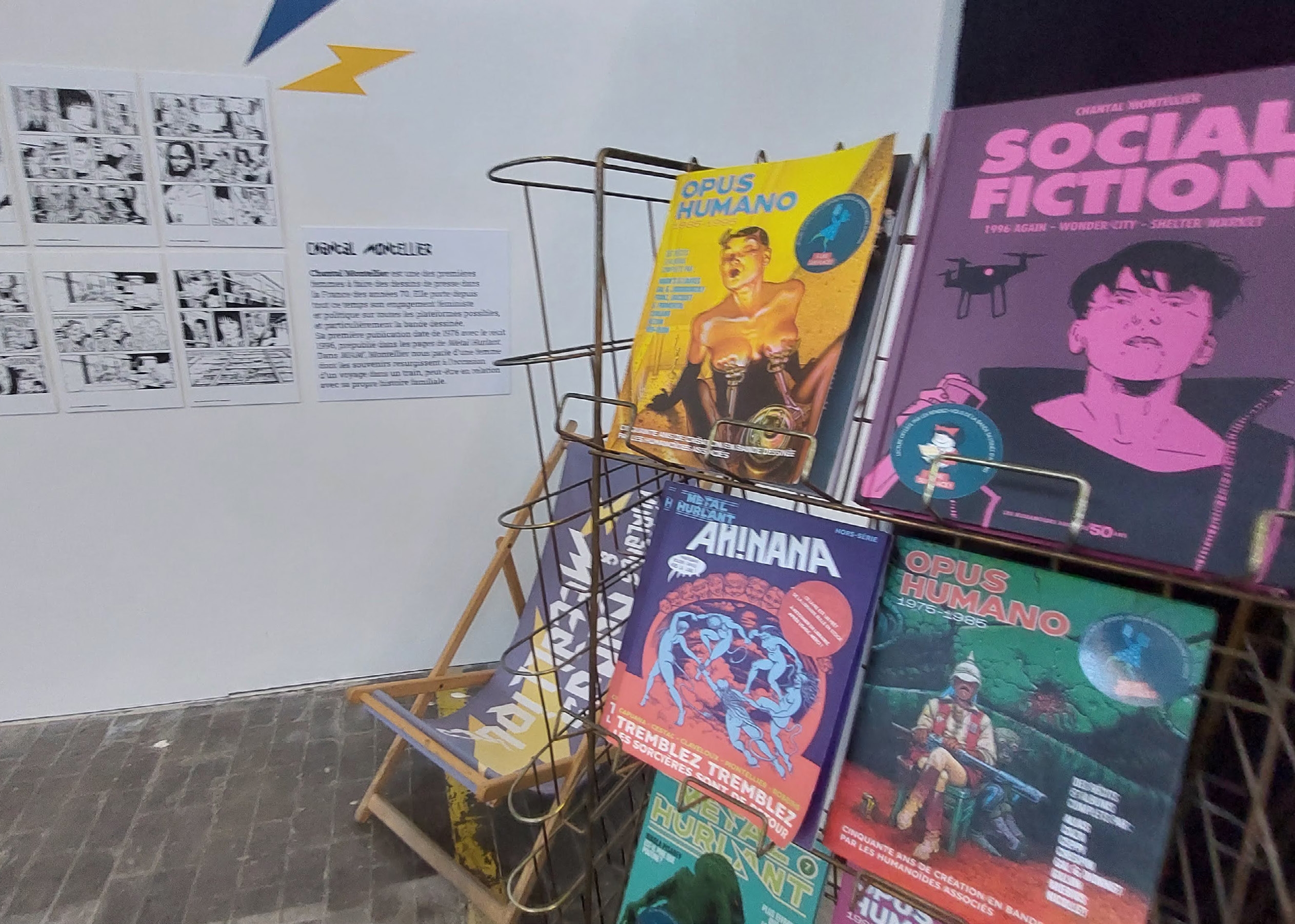 Présentoir d'exposition avec des ouvrages de Chantal Montellier, Social Fiction, les anthologies Opus Humano et la réédition d'Ah! Nana, photographié au RDVBD Amiens 2025.