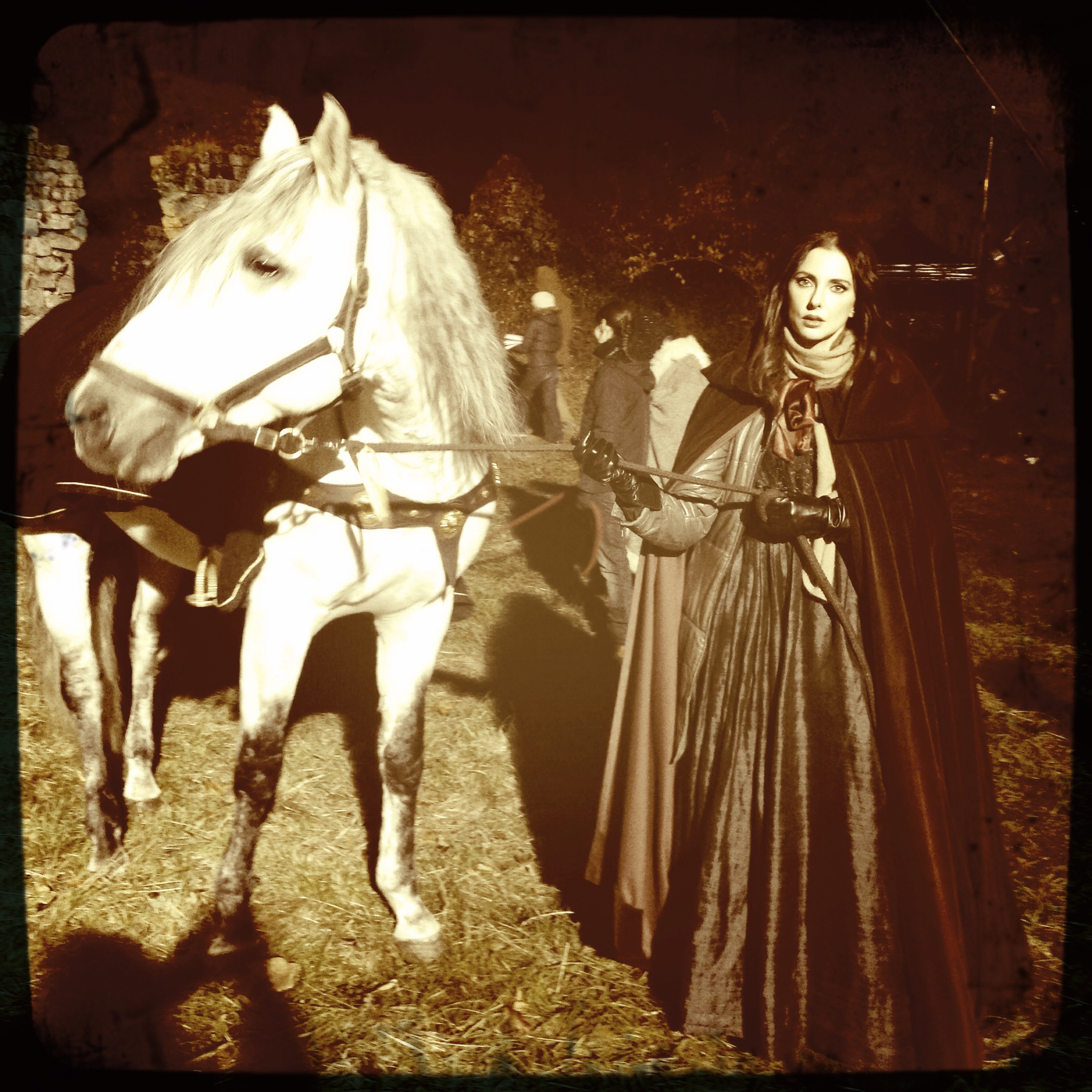 Frédérique Bel en costume, tenant un cheval blanc dans une scène de Metal Hurlant Chronicles.