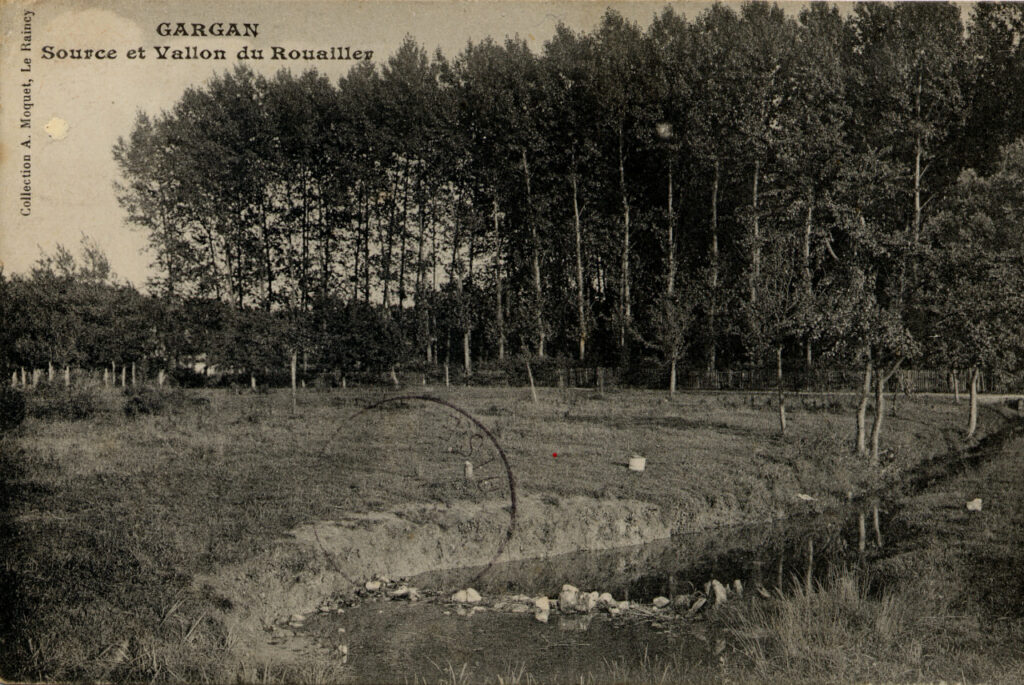 Carte postale ancienne représentant la source et le vallon du Rouailler à Gargan, dans un paysage boisé et ouvert.